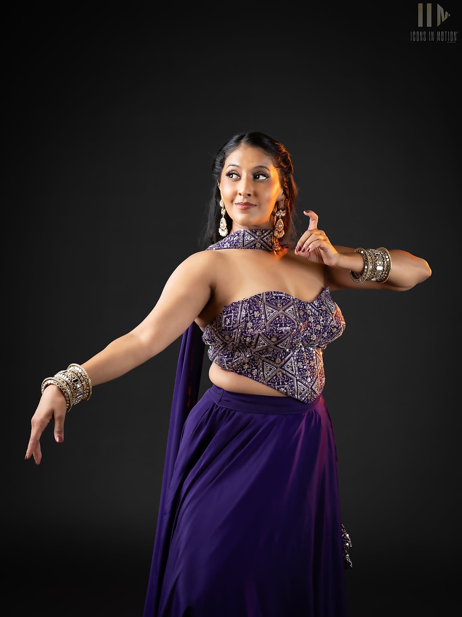 Dancer in a purple and silver lehenga with stacked bangles, glancing over one shoulder